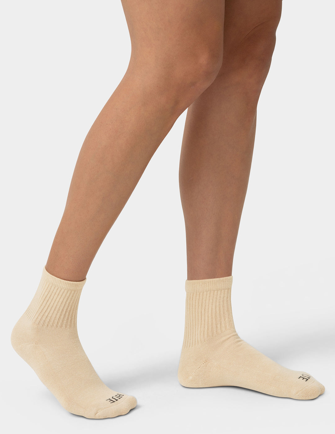 Beige socks worn by a person on a white background