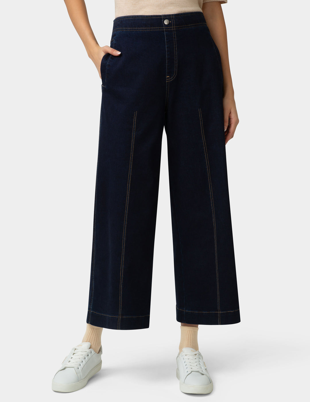 Person wearing dark blue wide-leg pants on a white background