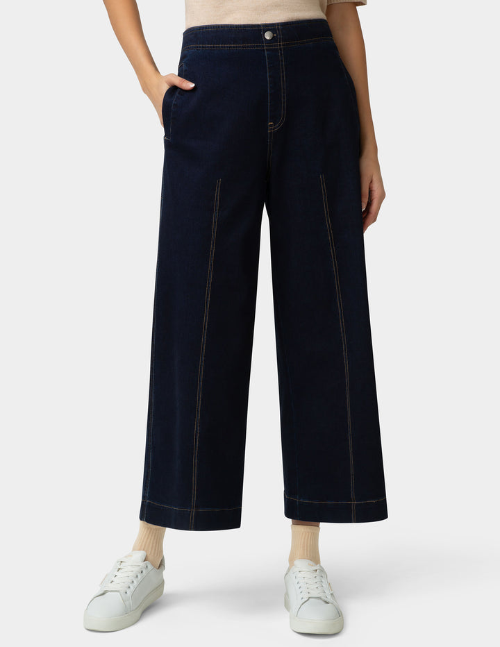 Person wearing dark blue wide-leg pants on a white background