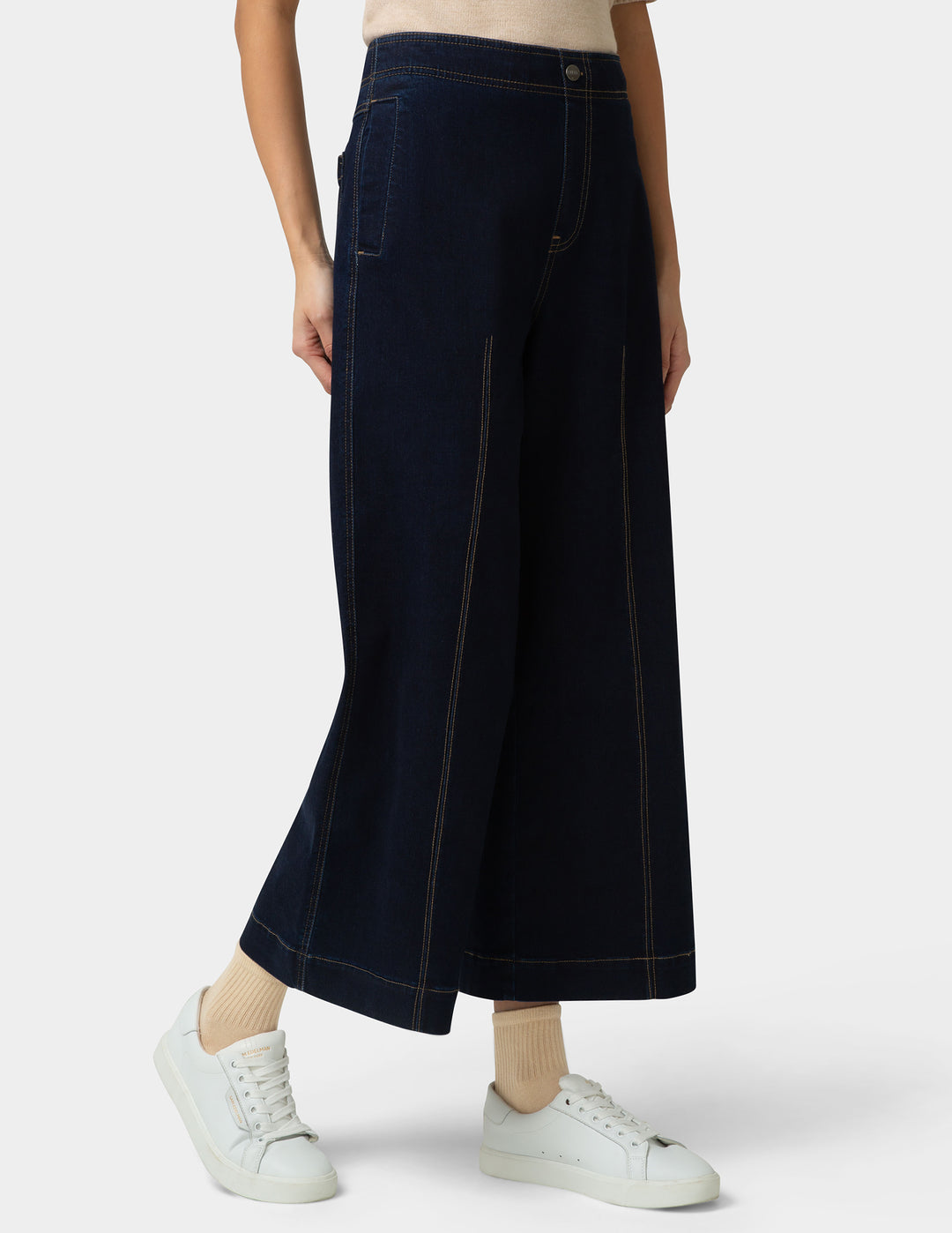 Person wearing dark blue wide-leg pants on a white background