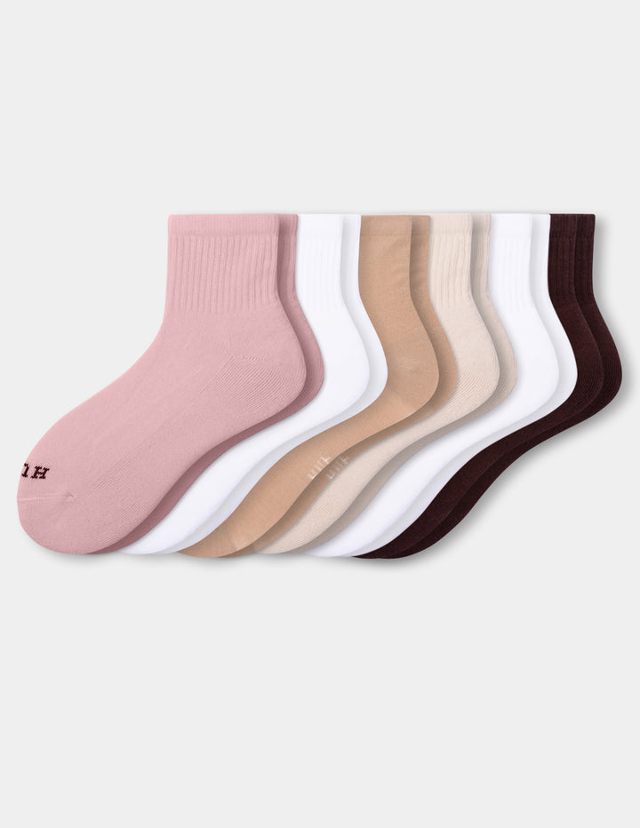 A set of six mini crew socks in various neutral shades, including dusty pink, white, tan, beige, and dark brown, arranged against a light gray background.
