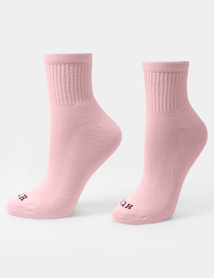 A pair of light pink crew mini socks with a small HUE logo on the toes, displayed against a light gray background.