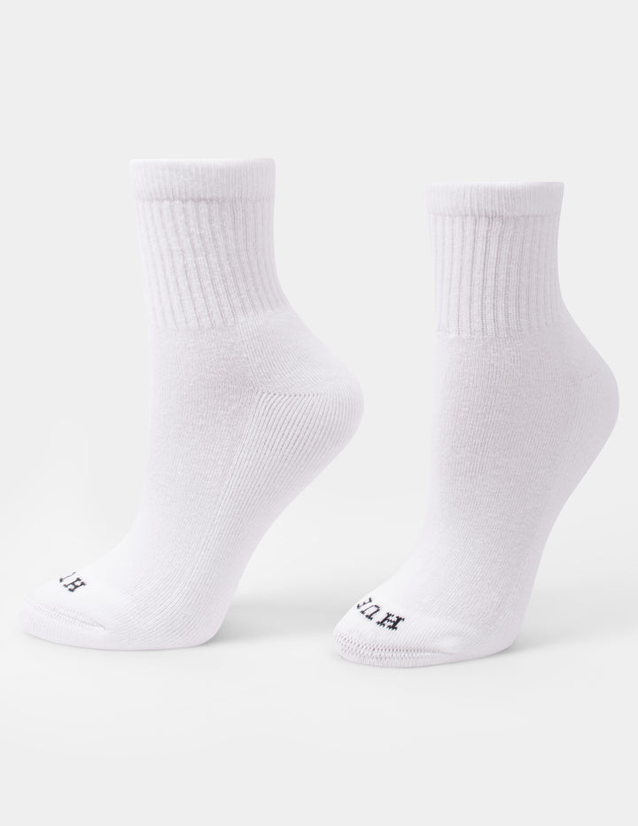 A pair of white crew mini socks with a small HUE logo on the toes, displayed against a light gray background.