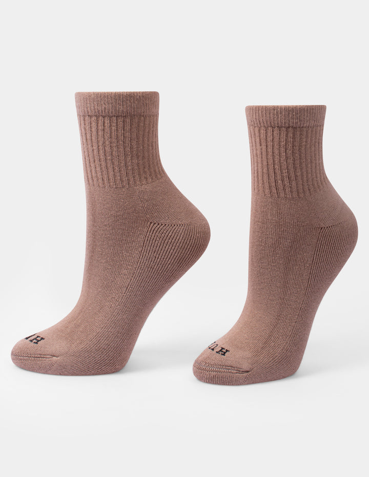 A pair of tan crew mini socks with a small HUE logo on the toes, displayed against a light gray background.
