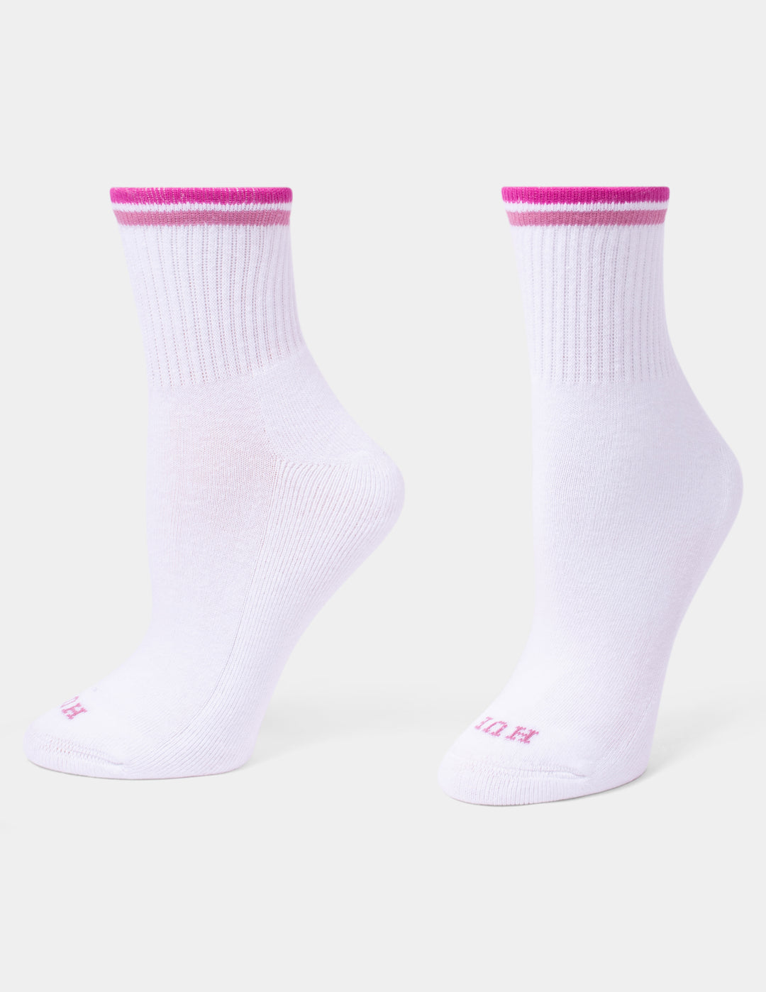 A pair of white mini crew socks with a vibrant pink double stripe at the ribbed cuffs and small pink lettering on the toes, displayed against a light gray background.