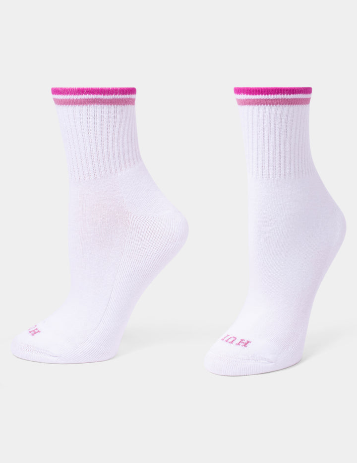 A pair of white mini crew socks with a vibrant pink double stripe at the ribbed cuffs and small pink lettering on the toes, displayed against a light gray background.