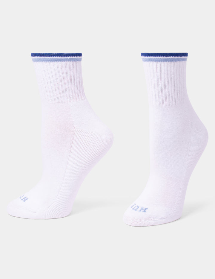 A pair of white mini crew socks with a blue ribbed cuff and light blue branding, shown against a light gray background.