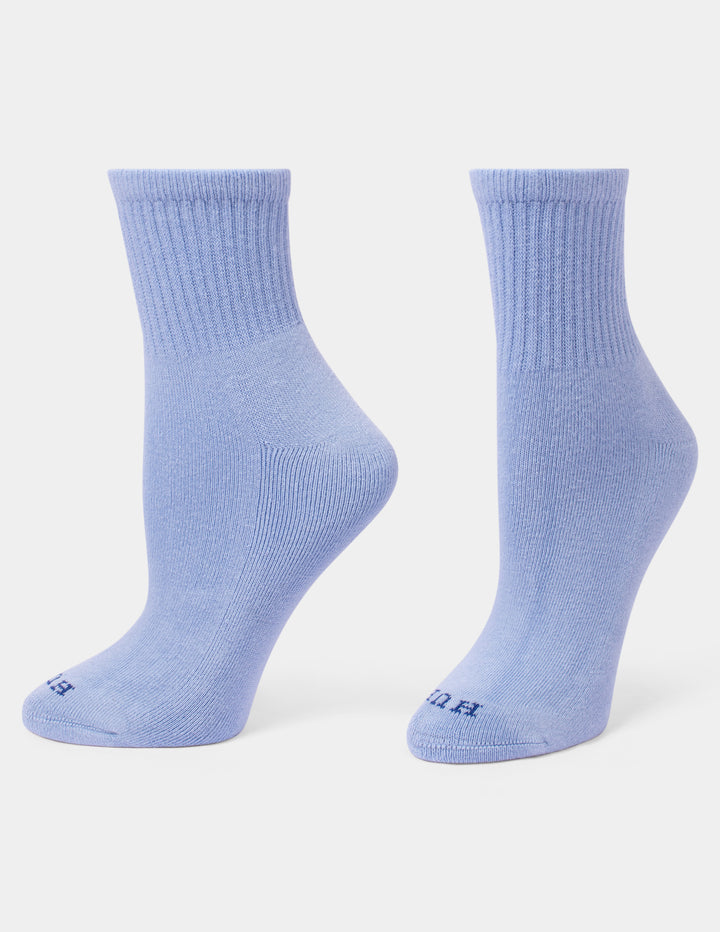 A pair of light blue mini crew socks displayed on foot forms against a light gray background.