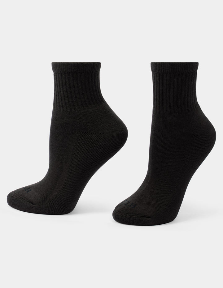 A pair of black mini crew length athletic socks displayed on foot forms against a light gray background.