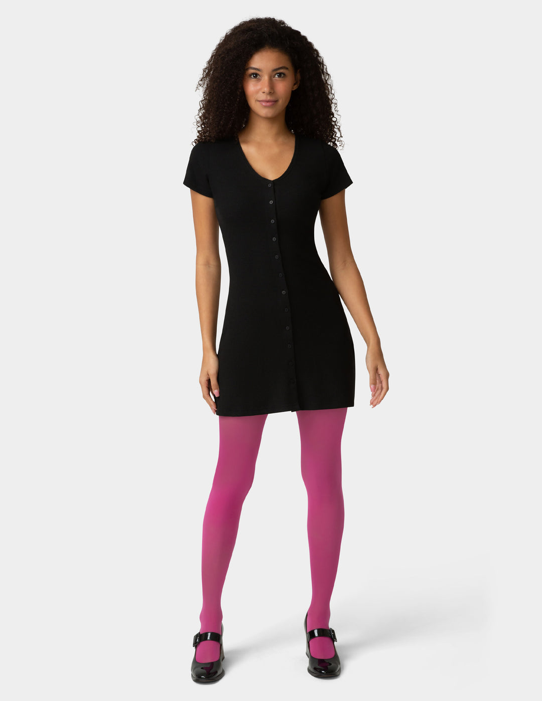 Woman wearing a black dress and pink tights on a white background