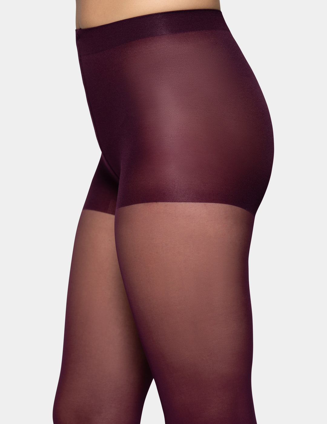 A close-up side view of a model wearing sheer burgundy tights against a light gray background.