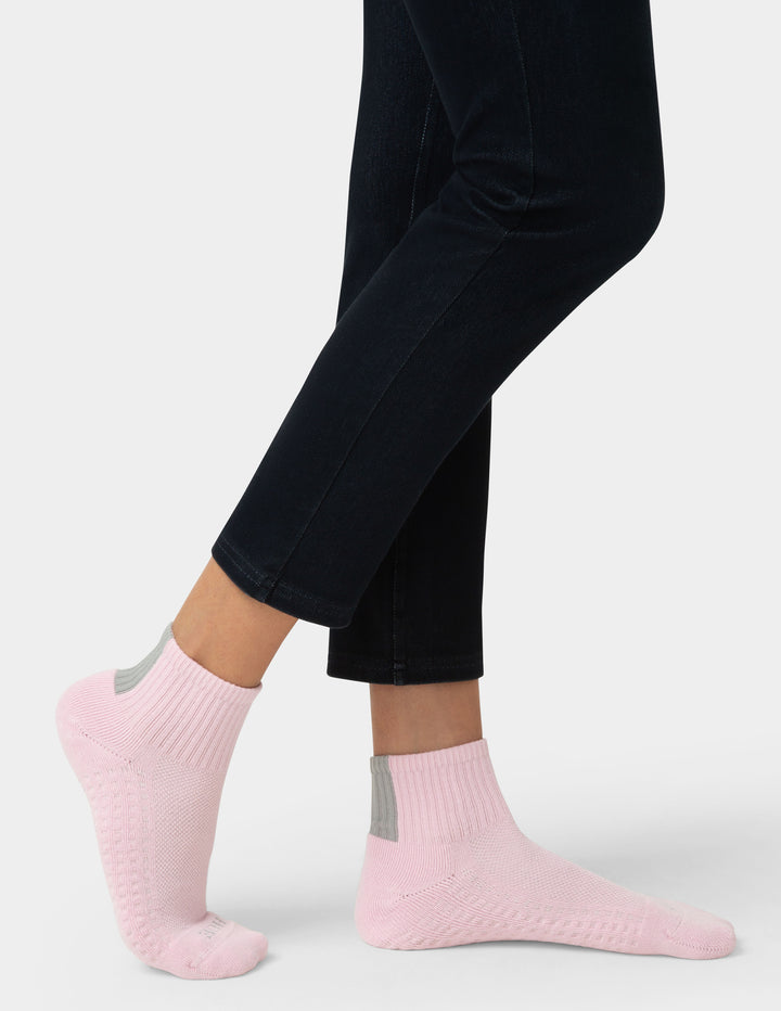 Person wearing pink socks with a white background