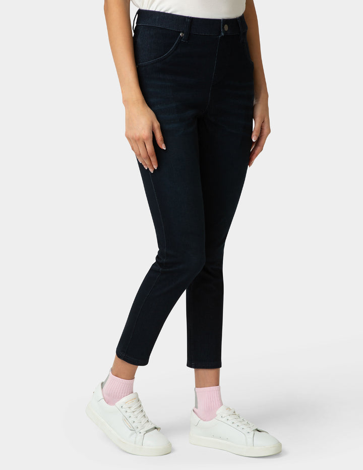 Person wearing black jeans and white sneakers on a white background