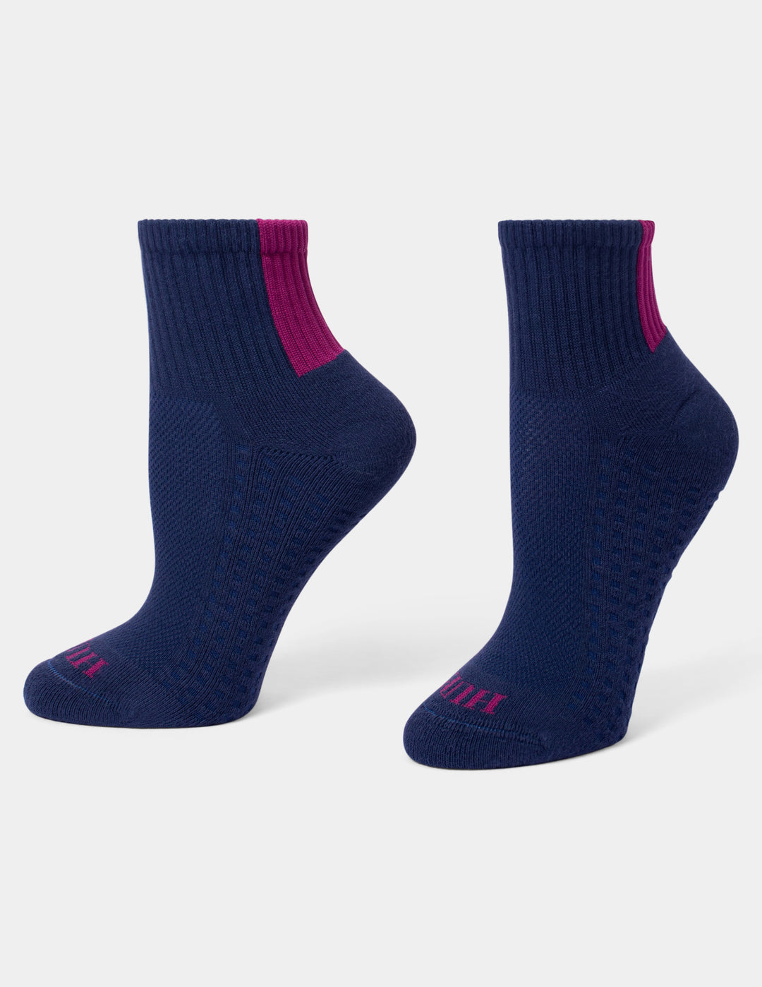 A pair of navy blue mini crew socks with a magenta pink accent stripe near the ribbed ankle cuff and matching pink branding on the toes, shown against a plain white background.
