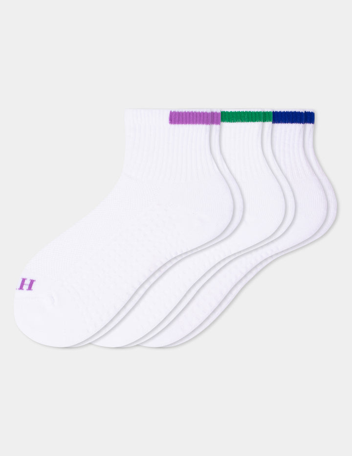 Three white ankle socks with colorful accents, fanned out on a light gray background. 
