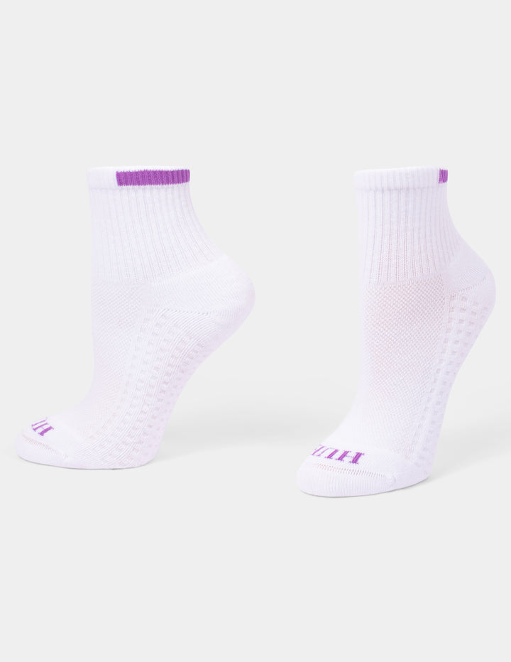 A pair of white mini crew athletic socks with purple accents displayed against a light gray background.