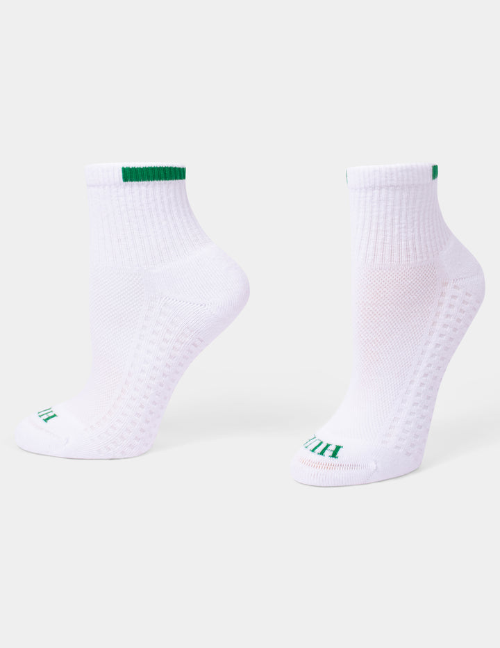 A pair of white mini crew athletic socks with green accents displayed against a light gray background.