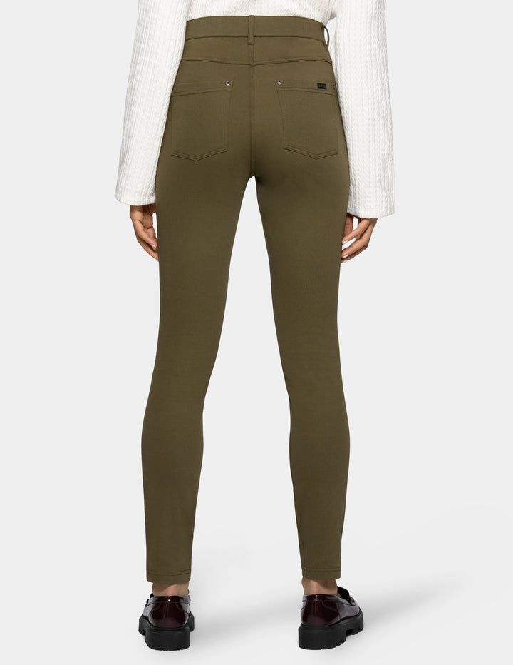 A person shown from the back wearing olive green leggings
