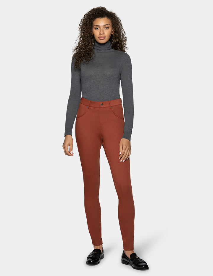 A woman modeling rust-colored high-waisted legging