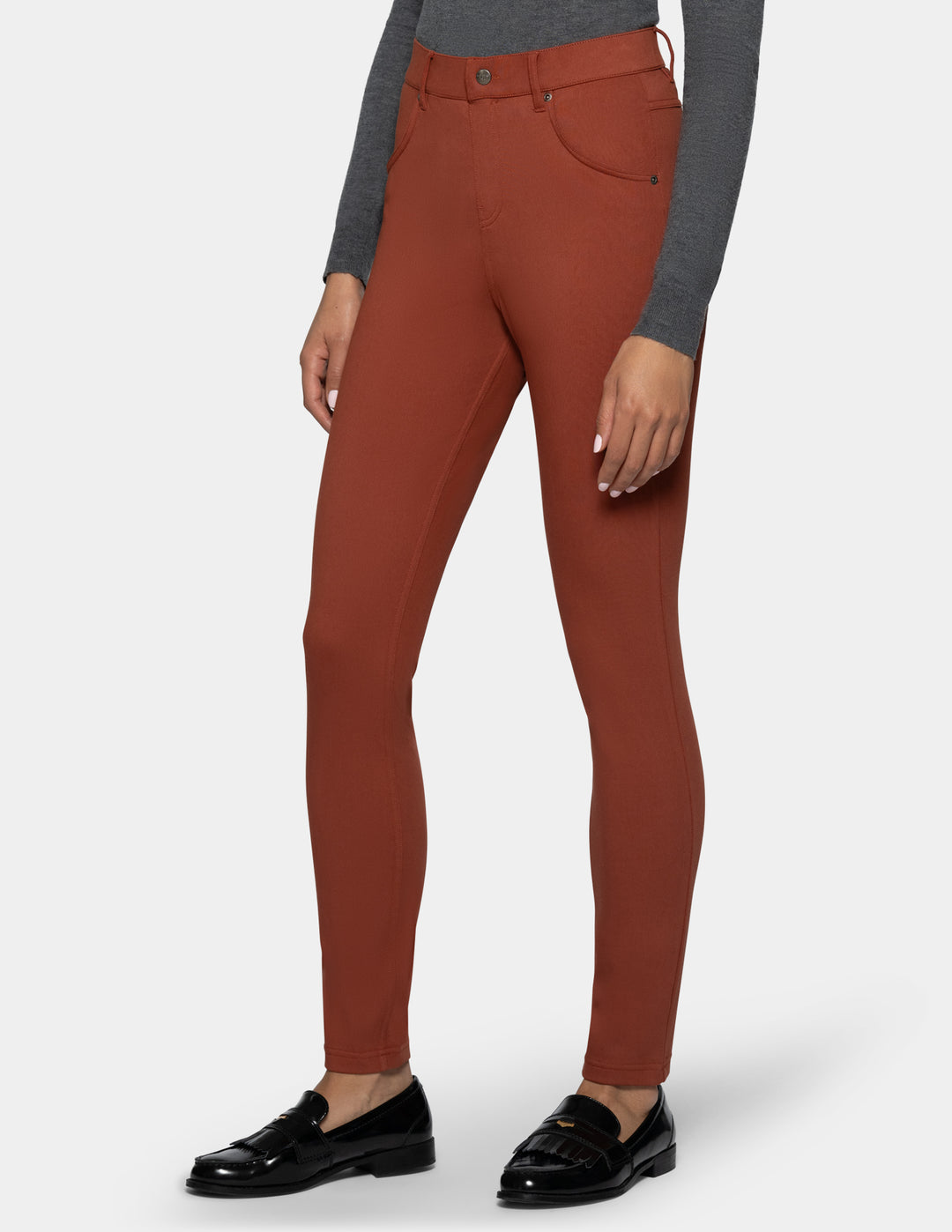 A model wearing high-waisted rust-colored leggings
