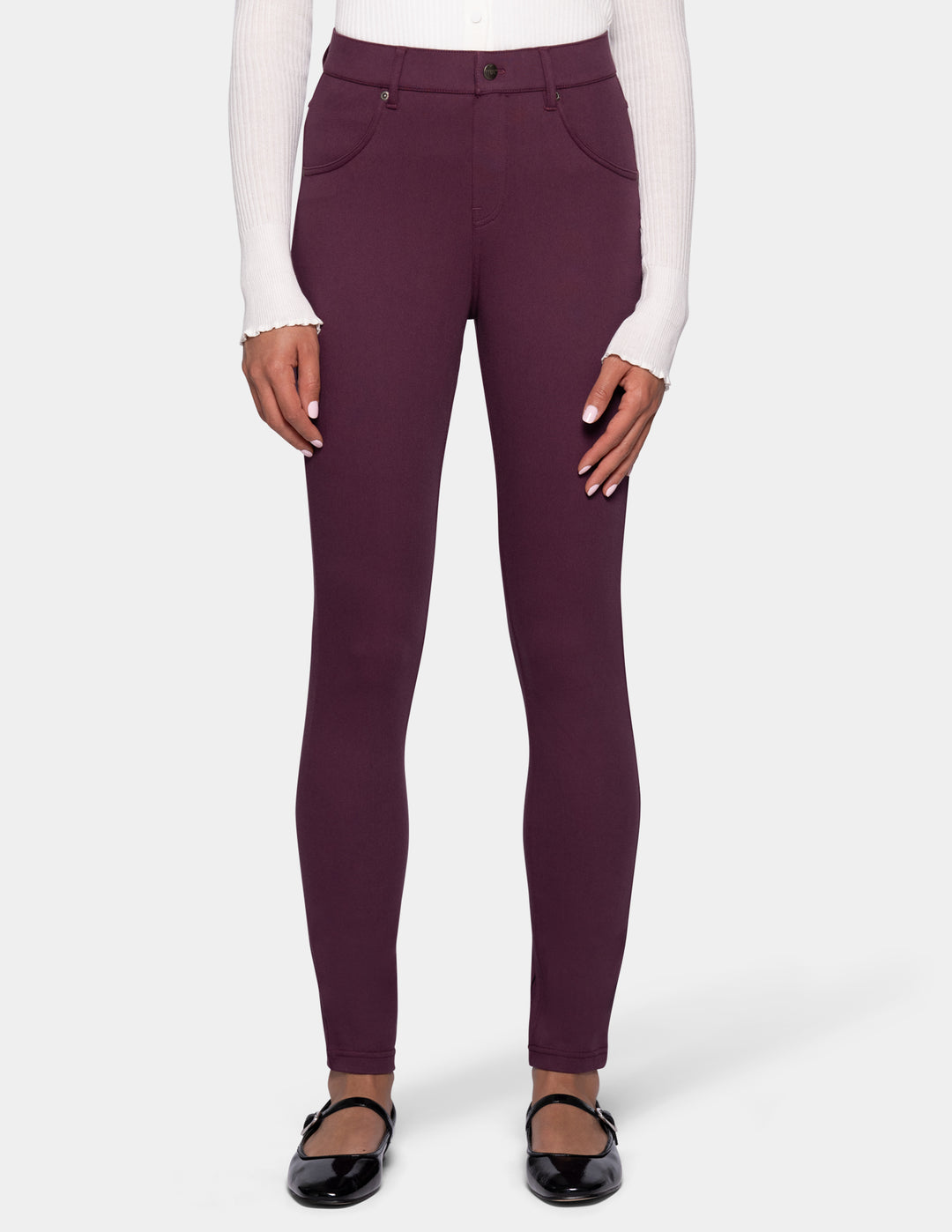 A model wearing a pair of dark plum leggings