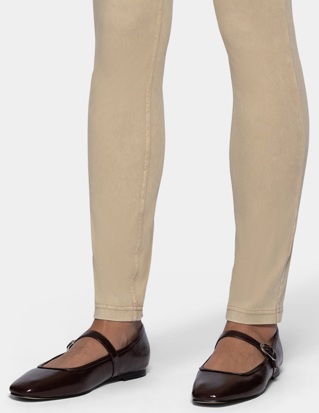 A close-up of a person's legs wearing beige leggings