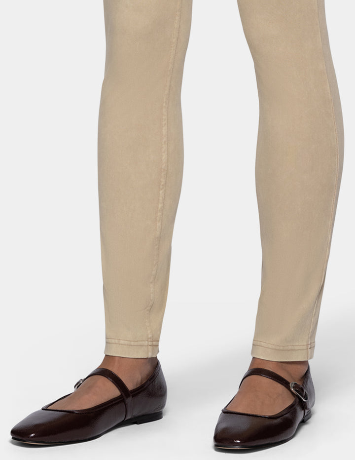 A close-up of a person's legs wearing beige leggings