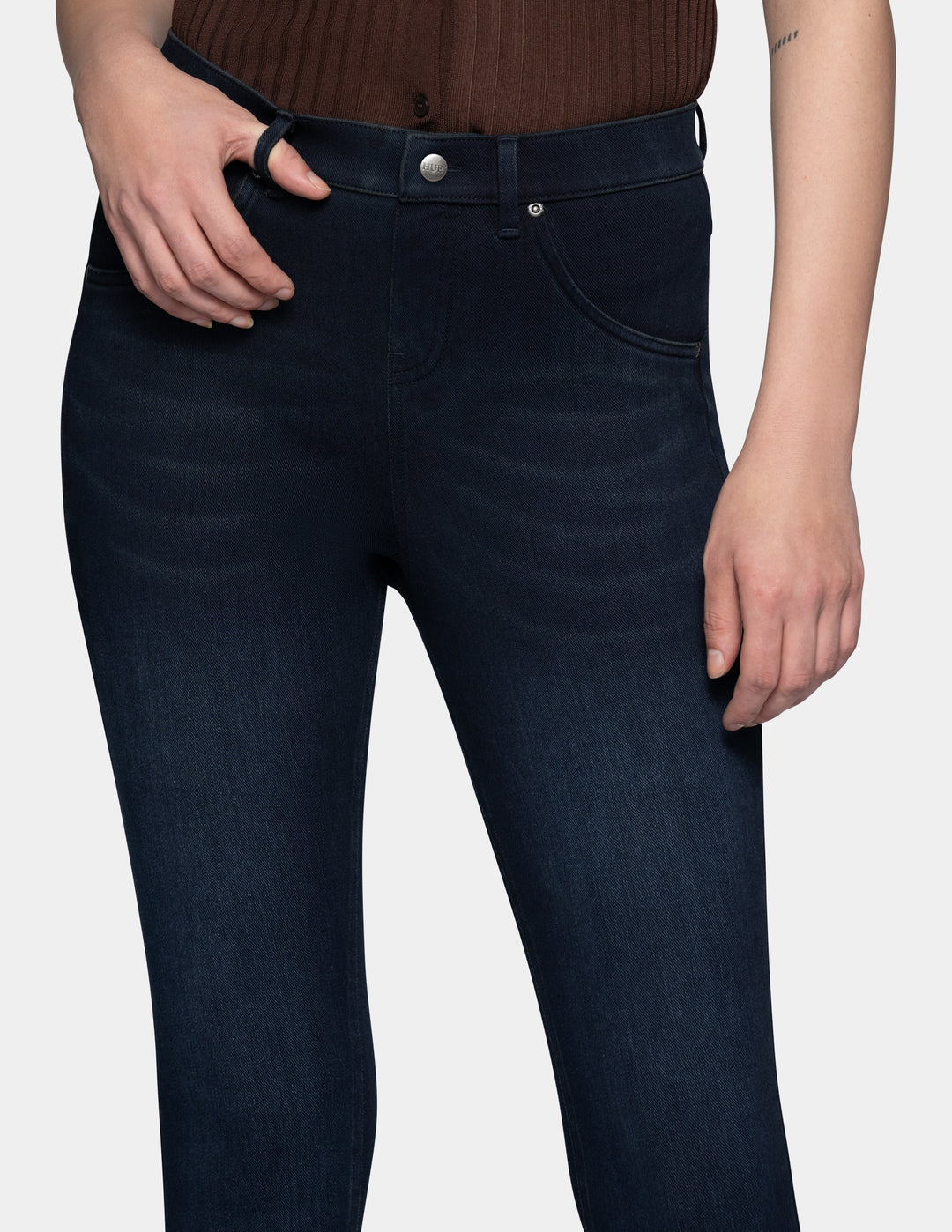 A model wearing dark blue leggings paired with a brown top.