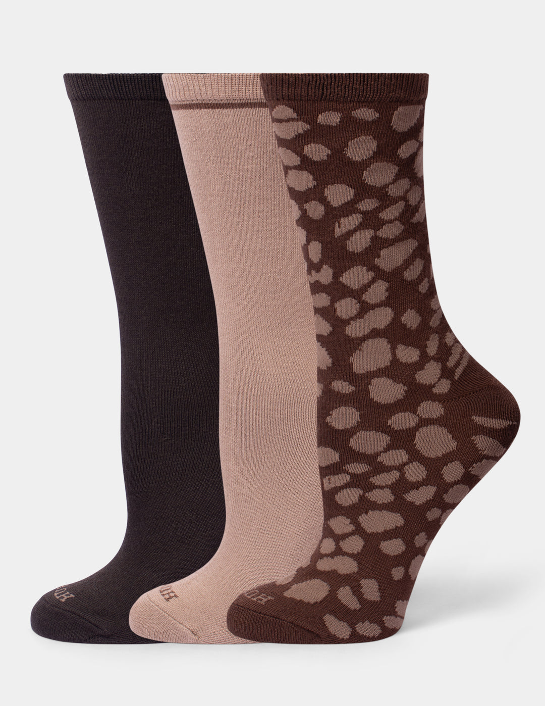 Three neutral color crew socks on a light gray background. 