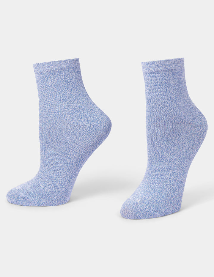 A pair of light blue textured ankle socks displayed on foot forms against a clean gray background.