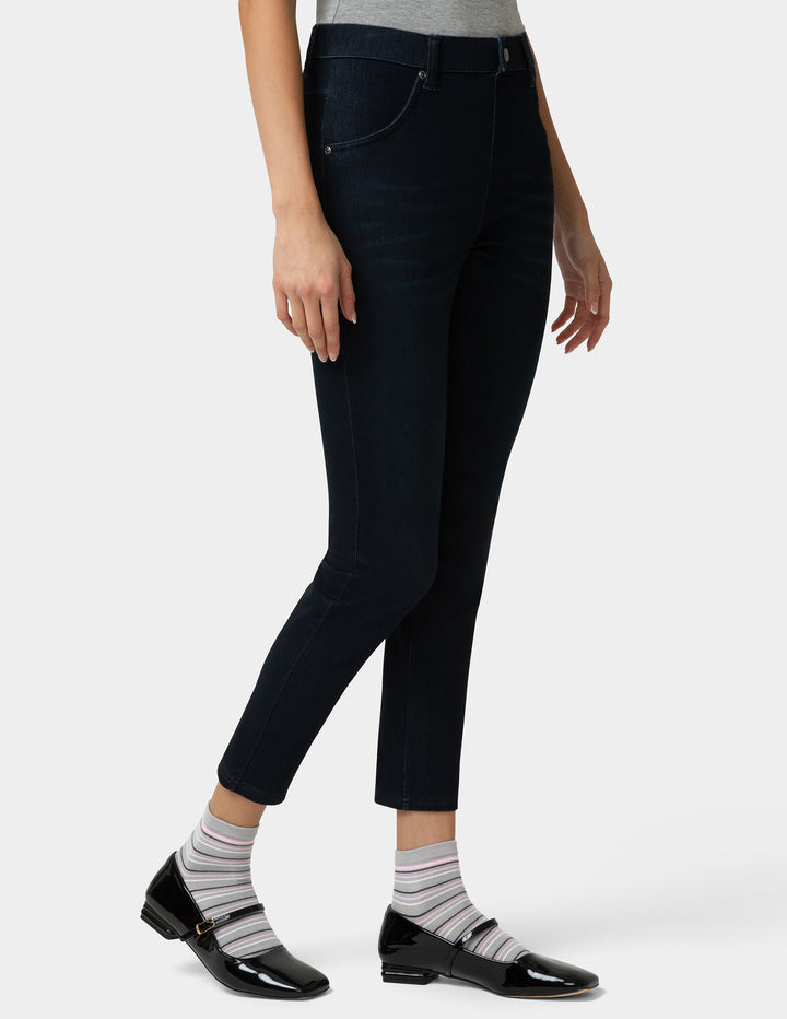 Person wearing dark blue jeans and striped socks on a white background