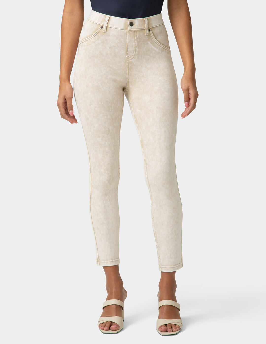 Person wearing beige jeans on a white background