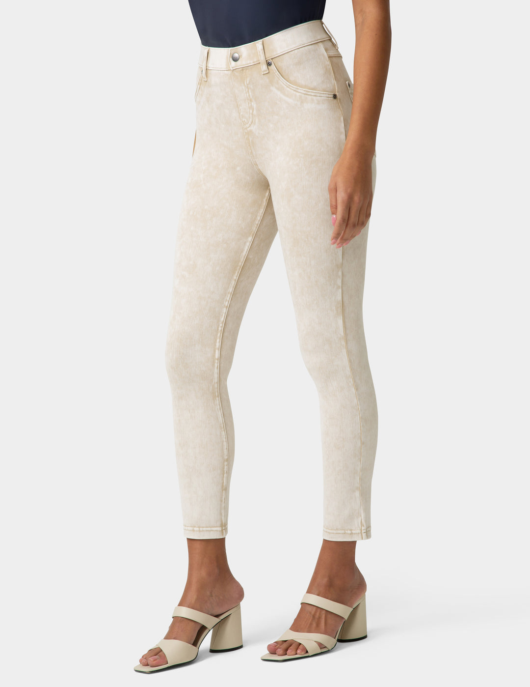 Person wearing beige jeans on a white background