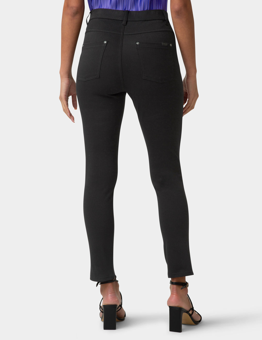 Black pants worn by a person on a white background