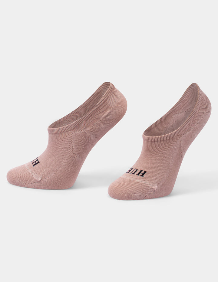 A pair of liner socks in a dusty rose pink color, set against a clean light gray background.