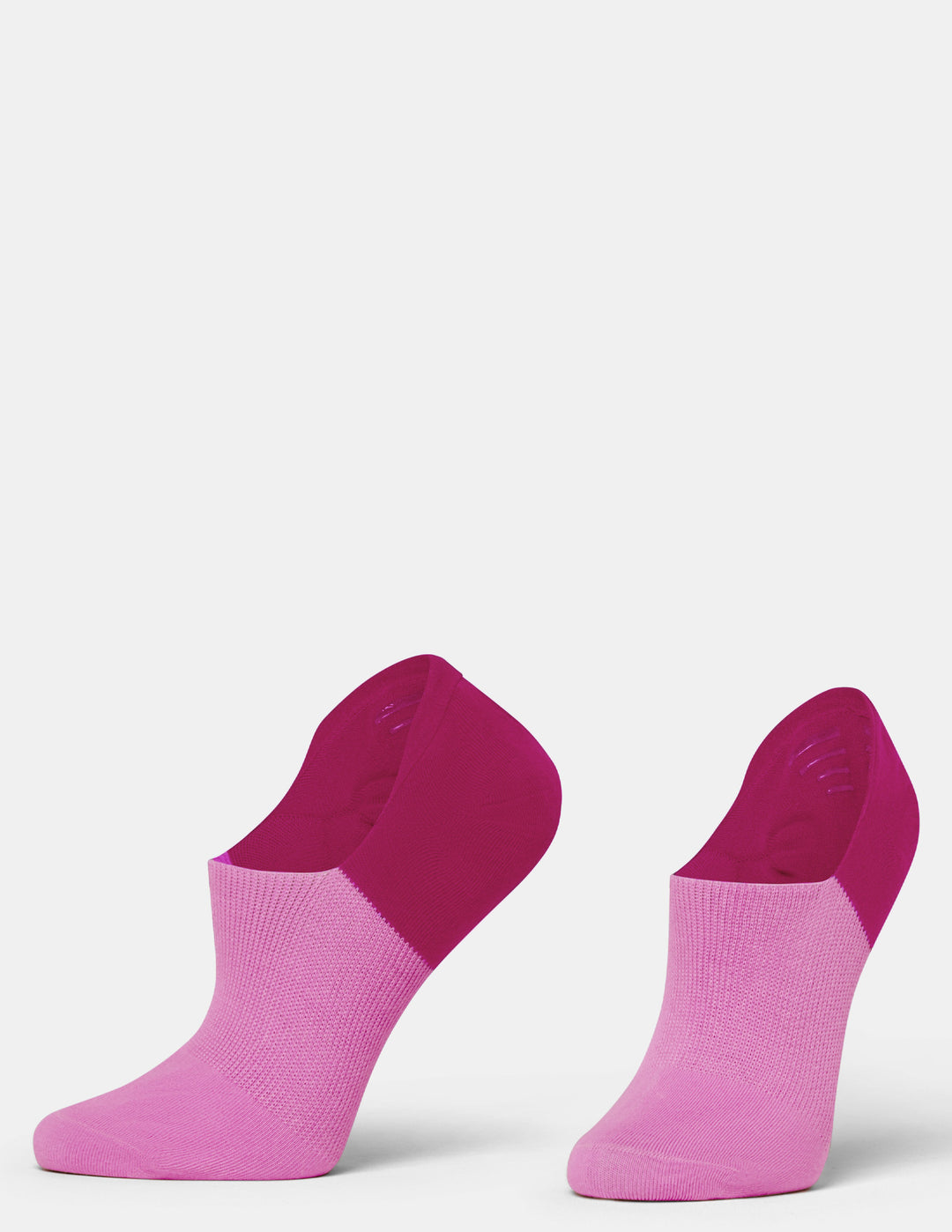 A pair of low-cut ankle socks in two shades of pink, with a darker magenta heel, shown against a plain light gray background.
