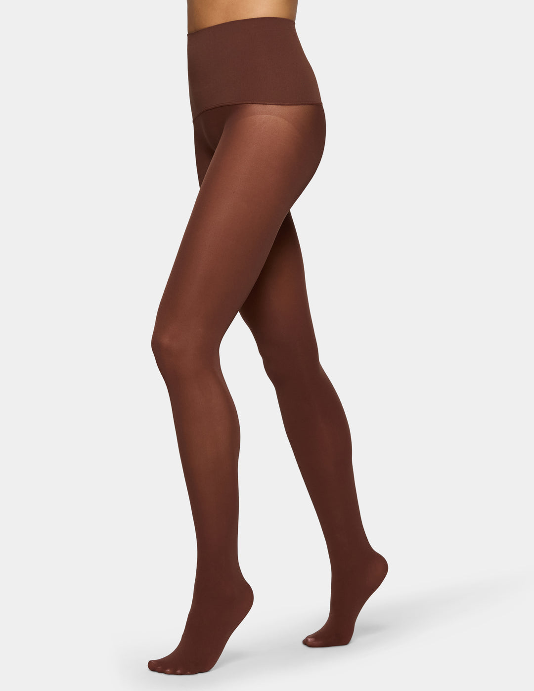 A model's legs wearing sheer, medium-brown tights against a light gray background.