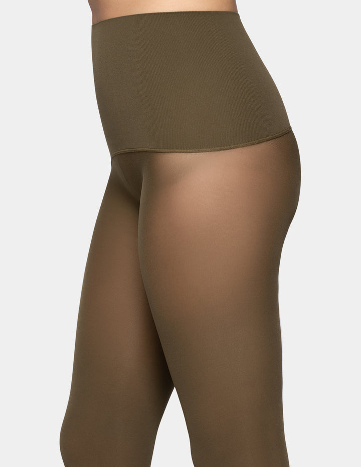 A close-up side view of a model wearing high-waisted sheer tights in a muted olive-brown shade against a light gray background.