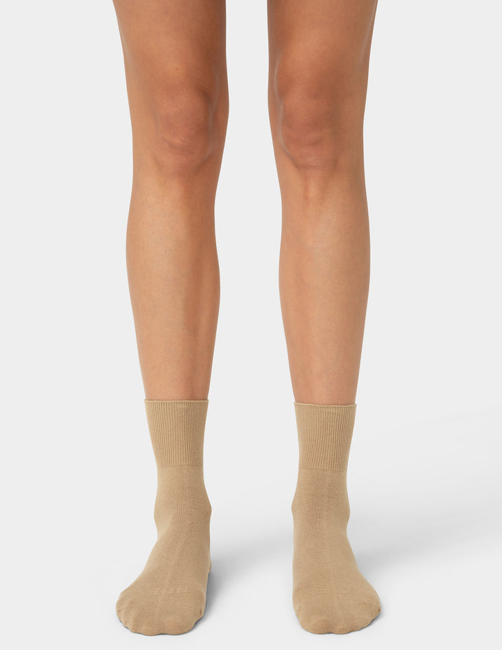 Beige socks worn by a person on a white background