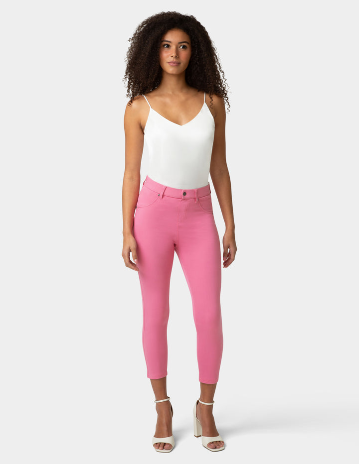 Woman wearing pink pants and a white top on a white background