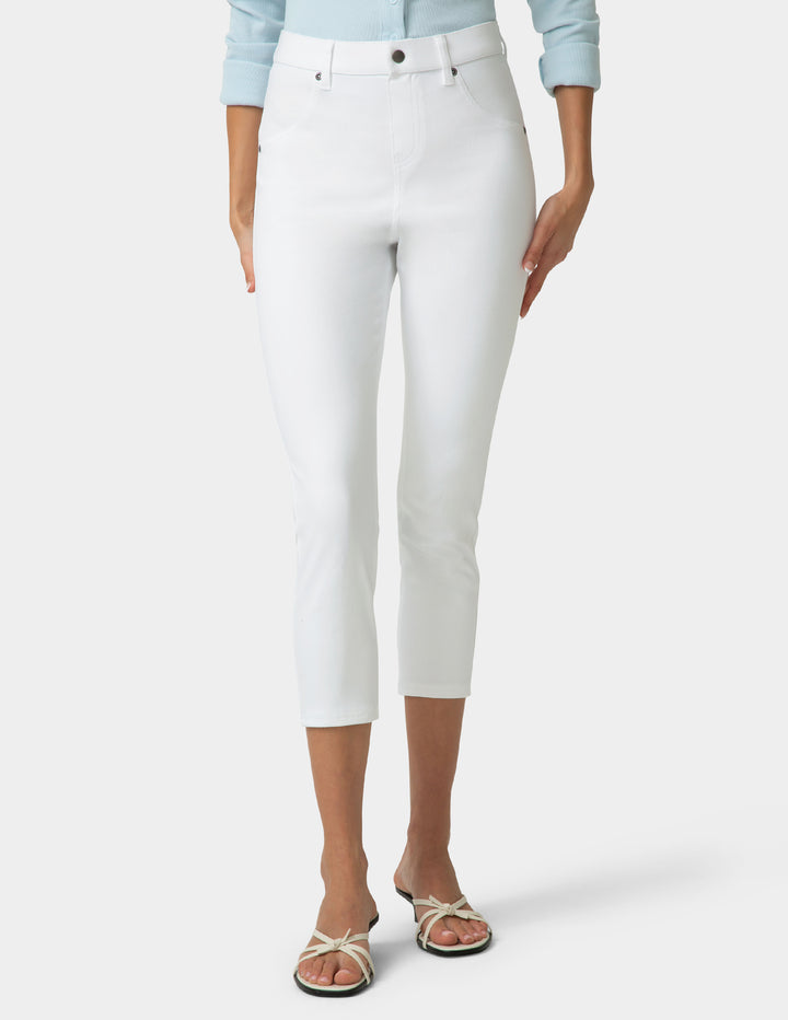 Person wearing white capri pants on a plain background