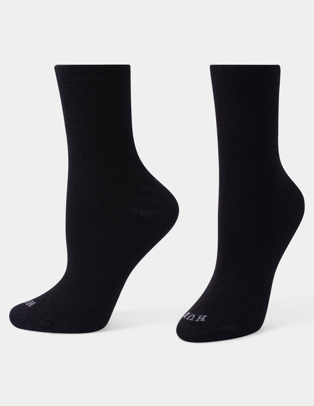 A pair of black crew socks shown from the back against a light gray studio background.
