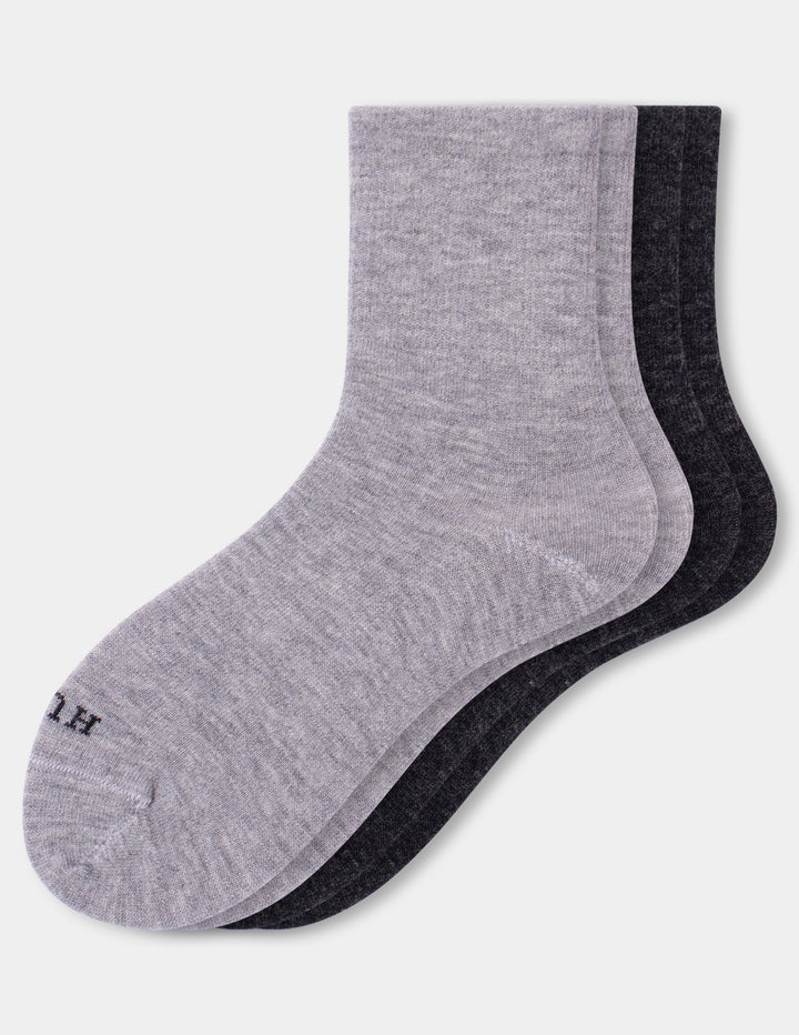 Two pairs of crew socks stacked together on a light gray background. The front sock is heather light gray and the back pair is a dark charcoal gray.