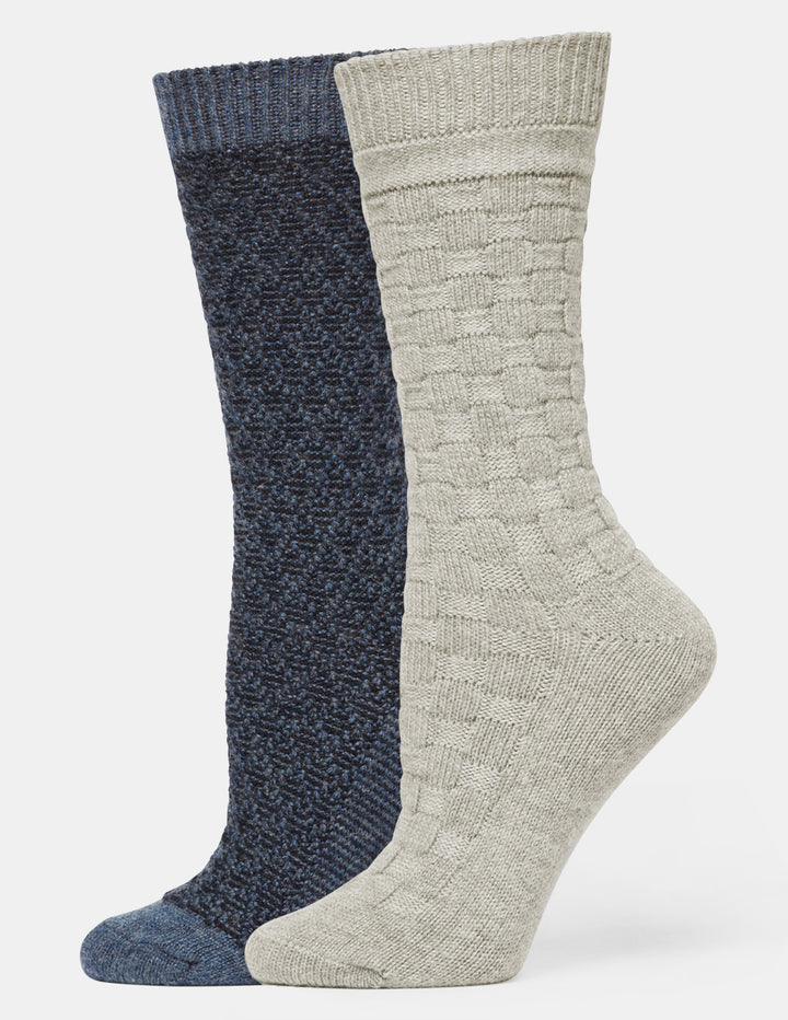 Two crew socks shown on invisible forms against a light gray background. One sock is heathered dark navy blue, and the other is heathered light beige with a textured cable-knit pattern.