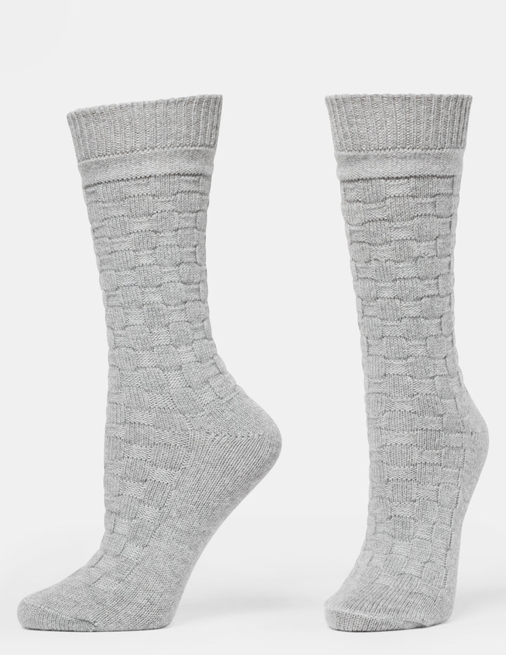A pair of light gray crew socks with a textured basketweave knit pattern, displayed on invisible forms against a plain white background.