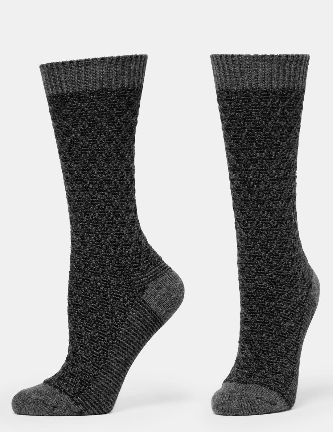 A pair of black textured crew socks shown from the side and back on a light gray background.