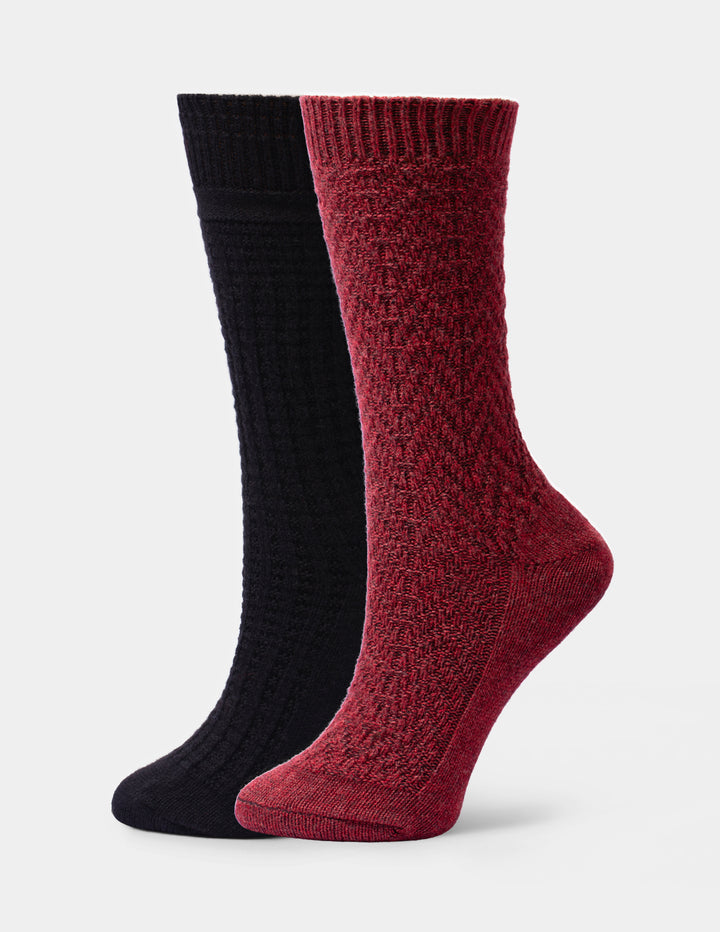 Two crew socks shown on invisible forms against a white background, one in black and one in maroon red, both with a textured knit pattern.