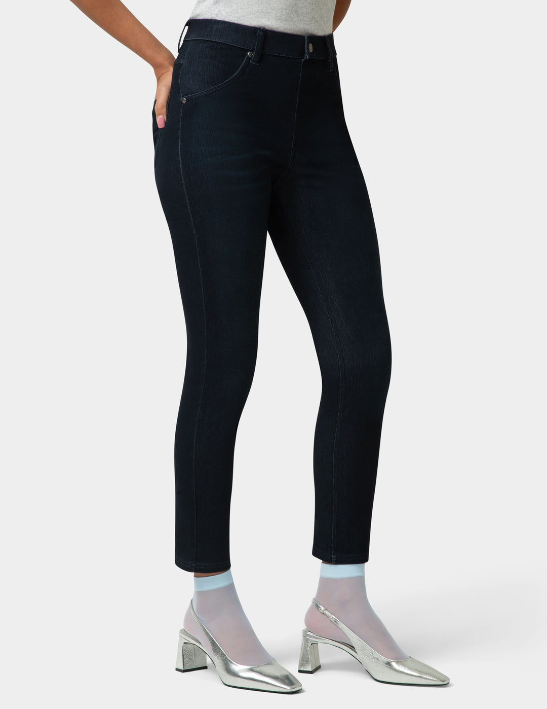 Person wearing black jeans and silver shoes on a white background