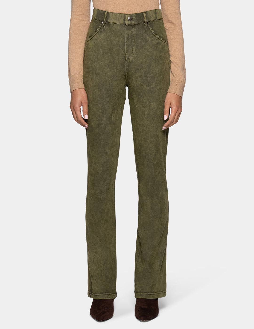 A model wearing olive green bootcut jeans, styled with a beige long-sleeve top and dark brown pointed-toe boots against a light gray background.