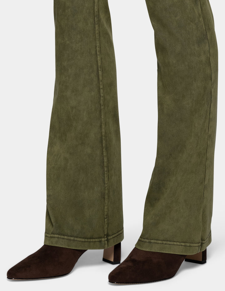 Close-up of a person's legs wearing olive green bootcut pants and dark brown pointed-toe heeled boots against a light gray background.